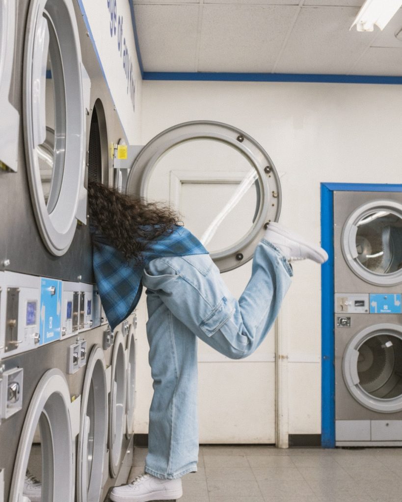 a woman leaning into washing machine